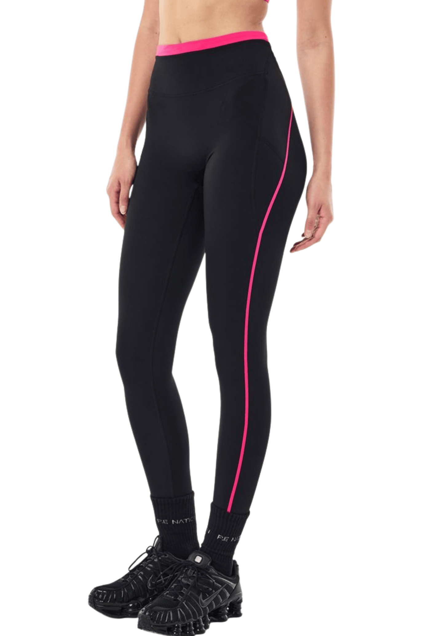 Black high-waisted athletic leggings with a bright pink waistband and a pink side stripe, shown on a model from the waist down wearing black sneakers.