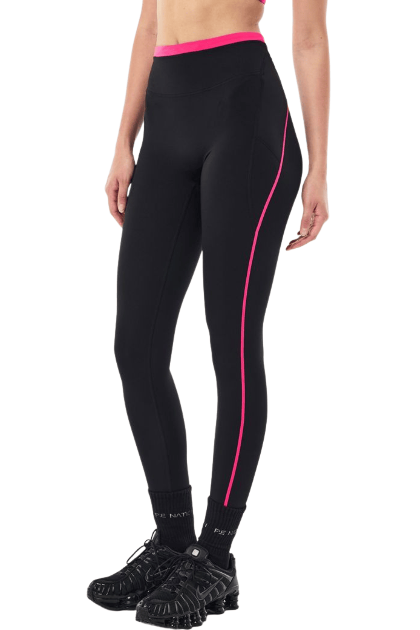 Black high-waisted athletic leggings with a bright pink waistband and a pink side stripe, shown on a model from the waist down wearing black sneakers.
